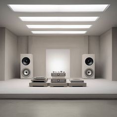 an empty room with speakers on the floor