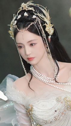 a woman in a white dress with pearls on her head