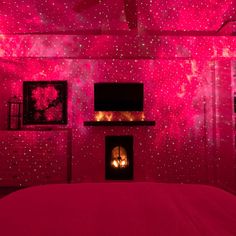 a bed room with a neatly made bed and pink lights on the wall above it