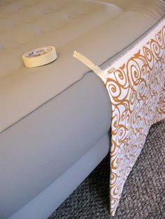 a bed with a white and gold bedspread sitting on top of it