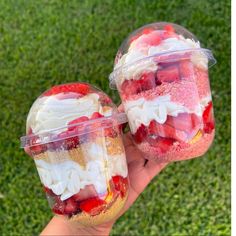 two desserts in plastic containers with strawberries and other toppings on the top