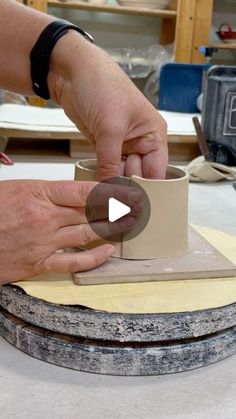 a person is making a vase out of clay