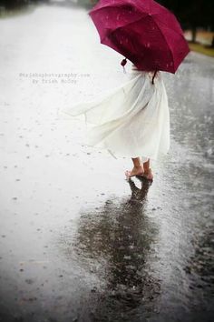 a woman walking in the rain with an umbrella