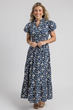 This navy maxi is covered in a pretty off white and chartreuse floral print. The sweet ruffle trimmed collar gives way to a notch neckline, and the cinched elastic waistband flows into a tiered maxi skirt. Short balloon sleeves complete the look. Dress it up with gold earrings and heels for a fall wedding, or simply style it with sandals or booties and hoops!  Pull-on fit Sleeves are lined Cinched elastic waist  Elastic sleeve... Casual Tiered Maxi Dress With Ditsy Floral Print, Casual Floral Print Tiered Maxi Dress, Casual Floral Print Maxi Dress With Tiered Skirt, Off Shoulder Jacket, Tiered Maxi Skirt, Skirt Short, Blue Door, Navy Floral, Floral Maxi