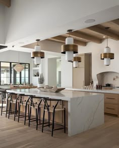 a large kitchen with marble counter tops and bar stools