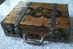 an old wooden box with metal handles on the floor next to a carpeted surface