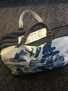 a blue and white bag sitting on top of a carpeted floor next to a wall