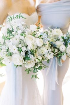 two bridesmaids holding bouquets of white flowers