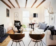 a living room filled with white furniture and lots of wood flooring next to a fire place