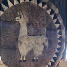 a llama is depicted on the back of a decorative wall hanging in a shop