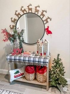 a christmas scene with presents under a mirror on a shelf and a small tree in front of it