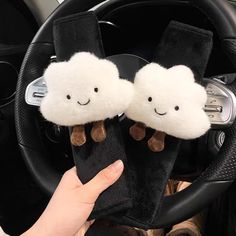 two fluffy clouds are sitting on the steering wheel