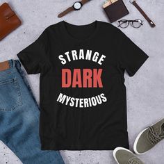 Strange dark and mysterious, Mr. Ballen Tell Me A Bedtime Story, MrBallen Merch, Mr. Ballen Merch, Tiktok Mr. Ballen, Strange Dark Mysterious, Short-sleeve unisex t-shirt This t-shirt is everything you've dreamed of and more. It feels soft and lightweight, with the right amount of stretch. It's comfortable and flattering for all.  * 100% combed and ring-spun cotton (Heather colors contain polyester) * Fabric weight: 4.2 oz/yd² (142 g/m²) * Pre-shrunk fabric * Side-seamed construction * Shoulder- Black Fandom T-shirt For Halloween, Black Fandom T-shirt With Screen Print, Black Fandom Screen Print T-shirt, Black Letter Print T-shirt For Fan Conventions, Black Fandom T-shirt With Letter Print, Horror Cotton T-shirt With Letter Print, Horror Themed Letter Print Cotton T-shirt, Black Cotton Fandom T-shirt, Themed Streetwear T-shirt With Letter Print