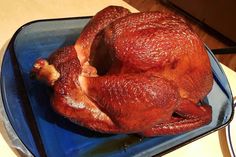 a whole chicken sitting on top of a blue plate