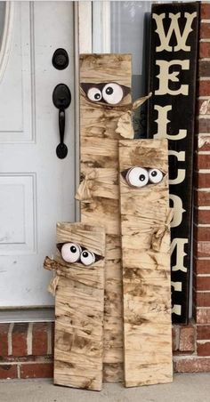 some wood sticks with eyes on them sitting in front of a door