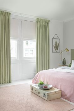 a bedroom with a pink bed and green curtains