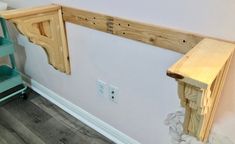 a wooden shelf sitting on the side of a wall next to a green step ladder