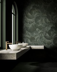 two white bowls sitting on top of a counter in front of a wallpapered room