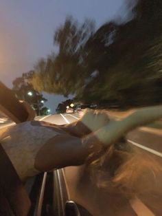 a person riding in the back of a car at night