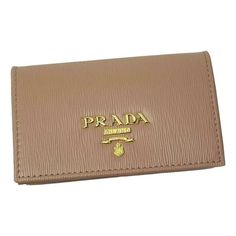 This Prada card case wallet features beautiful neutral leather that makes it the perfect accessory for anybody. The Prada Paris logo featured on the front is eye-catching. Its large interior and two slip pockets mean organizing is a breeze. You'll never want to leave home without this sophisticated wallet. Includes authenticity cards and Prada box. Model: 1MC122 Measurements: 4.5" x 1" x 2.5" (LWH) Cipria Beige vitello grain leather Card holder/wallet Gold Prada Paris logo Made in Italy Includes Gold Leather Wallet With Logo Plaque, Luxury Business Wallet With Gold-tone Logo, Luxury Business Wallets With Gold-tone Logo Plaque, Designer Compact Card Holder With Card Slots, Luxury Gold Wallets With Logo Plaque, Luxury Bifold Card Holder For Daily Use, Designer Gold Rectangular Card Holder, Designer Compact Wallets With Card Slots, Designer Compact Wallet With Card Slots