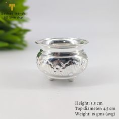 a silver vase sitting on top of a white table