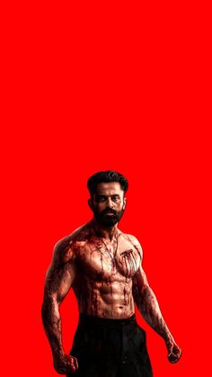 a man standing in front of a red background with his shirt off and no shirt on