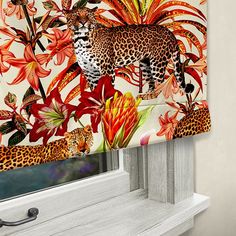 an animal themed window valance with flowers and leopards on the outside, in front of a white painted wall