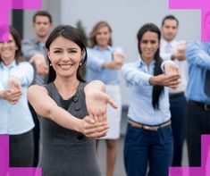 a group of people standing around each other with their arms in the air and pointing at something