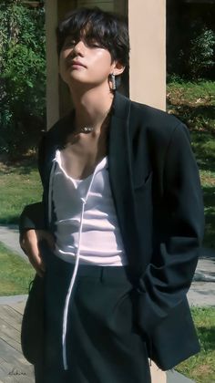 a young man wearing black shorts and a white shirt is standing in front of a building