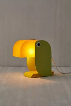 the lamp is shaped like a mushroom and has a yellow light on it's side