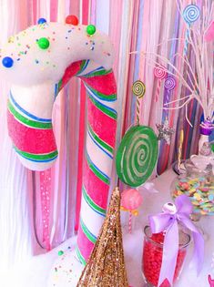 candy canes and candies are on display in front of pink curtained drapes