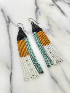 two tone beaded earrings with black, yellow and white beads on marble background - product images