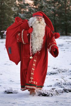 a man dressed as santa claus walking in the snow