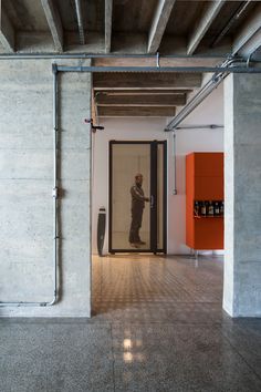 a man standing in front of a door with his reflection on the wall behind him