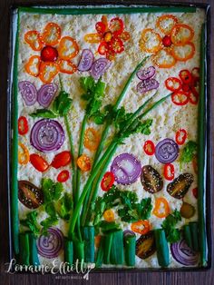 vegetables are arranged on top of rice in a square dish with green onions, carrots and celery