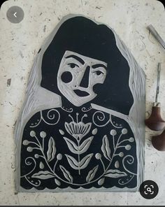 a black and white drawing of a woman with flowers on it's face next to some scissors