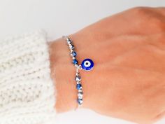 "Unique and elegant bracelet made just for you. Beautiful bracelet, in the color of your choice, with blue evil eye charm in silver or gold details, depinding on your choice . A very cute beaded everyday bracelet, fit on all wrists. Made from color string, with blue evil eye charm surrounded by crystal beads in icy blue color. , macrame slide lock closure. When a person wears an evil eye with them, it guards against misfortune and from bad things happening. Protective Evil eye Talismans like thi Silver Hand-strung Friendship Bracelet As Gift, Hand-strung Silver Friendship Bracelets As Gift, Symbolic Blue Bracelet Jewelry, Silver Beaded Evil Eye Bracelet Gift, Silver Beaded Evil Eye Bracelet For Gift, Blue Nickel-free Crystal Bracelet Gift, Blue Sterling Silver Beaded Bracelets As Gift, Blue Nickel-free Crystal Bracelet For Gift, Blue Hypoallergenic Charm Bracelet For Gift