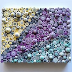 a painting made out of buttons on a white surface