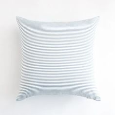 a blue and white striped pillow on a white wall