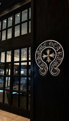 the entrance to a restaurant with glass doors and an emblem on the side of it