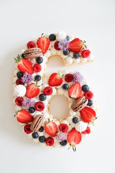 the number six is made up of fruit and cookies on top of white frosting