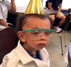 a young boy wearing a party hat and goggles