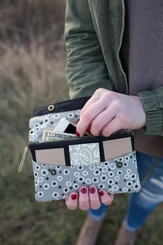 a woman is holding a wallet in her hand