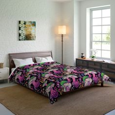 a bed room with a neatly made bed and a painting on the wall