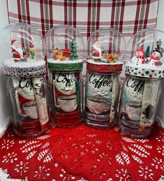 four glass jars filled with coffee beans on top of a red doily