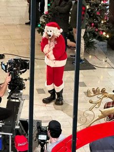 a man dressed as santa claus is filming