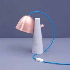 a marble lamp with a blue cord attached to it and a copper light on top