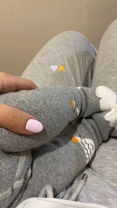 a woman with pink nails is laying on her stomach and holding onto an elephant toy