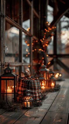 there are many lit candles on the wooden floor next to each other and one lantern