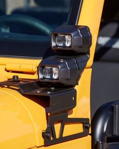 two lights on the front of a yellow jeep